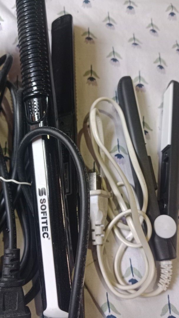 Sonar SN-823 and Sofitec Hair Straighteners (Category: Hair) located in San Miguel. Submitted by chriswajer65155 (Listing ID 1470944880, Image 3). Description: - Bundle of 3 black hair straighteners sold as a set - Includes Sonar SN-823 with a thick black body and warning symbol - Includes Sofitec model with a ribbed handle and white side accent - Includes a third flat iron featuring a white heating plate and cream-coloured power cord - All units