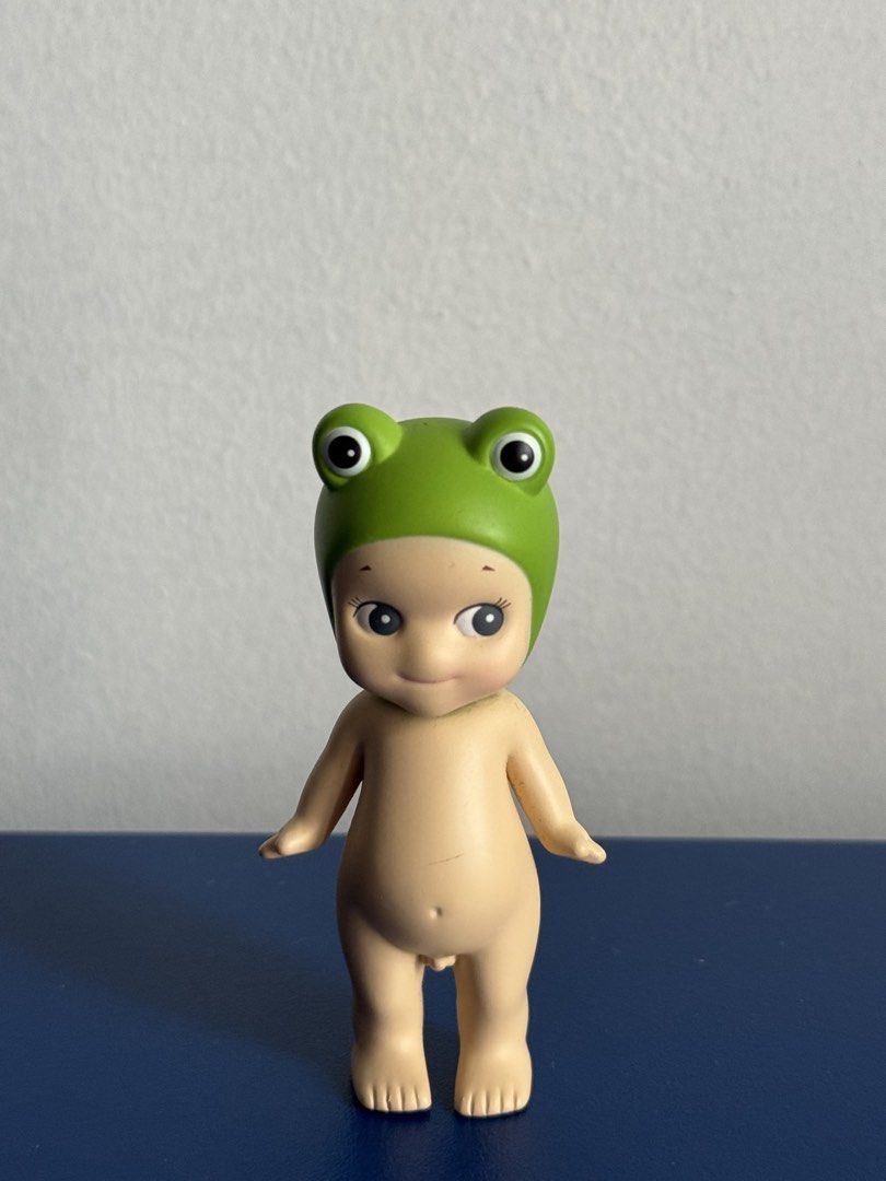 Sonny Angel Frog Mini Figure (Category: Designer & Blind Box Toys) located in Manila. Submitted by secondhandgcf (Listing ID 1470957994, Image 1). Description: - Authentic Sonny Angel collectible figure - Adorable design wearing a green frog hat with rosy cheeks and a sweet smile - Classic naked baby body featuring cute wings on the back - Stands firmly on its own - Condition note: Has a slight mark on the belly area - Perfect addition to any Son