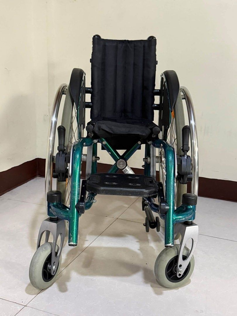 Sopur Youngster Wheelchair (Category: Wheelchairs) located in Manila. Submitted by calmdolphin.87b0e4 (Listing ID 1470957680, Image 2). Description: - Brand/Model: Sopur Youngster wheelchair - Color: Vibrant green and silver frame with black fabric seat and backrest - Portability: Foldable frame design for effortless transport and storage - Storage: Includes a handy storage bag attached to the back - Mobility & Safety: Manual push rims on large r
