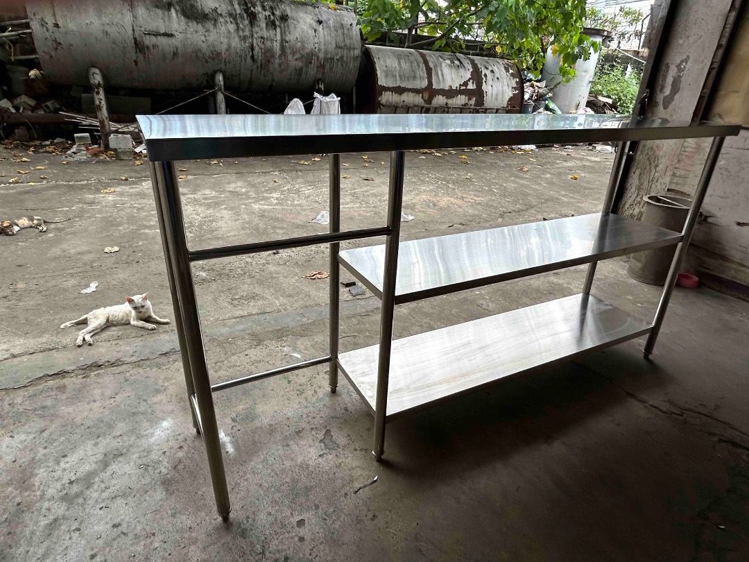 Stainless steel kitchen work table with double shelves (Category: Tables & Sets) located in Caloocan City. Submitted by brightdolphin_bfc4c6 (Listing ID 1471013534, Image 1). Description: Overall length: 2100 mm Overall height: 1100 mm Upper section height: 230 mm Left section width: 470 mm Main section width: 1476 mm - Heavy-duty commercial-grade stainless steel prep table - Clean and durable work surface on top - Two lower shelves provide extra