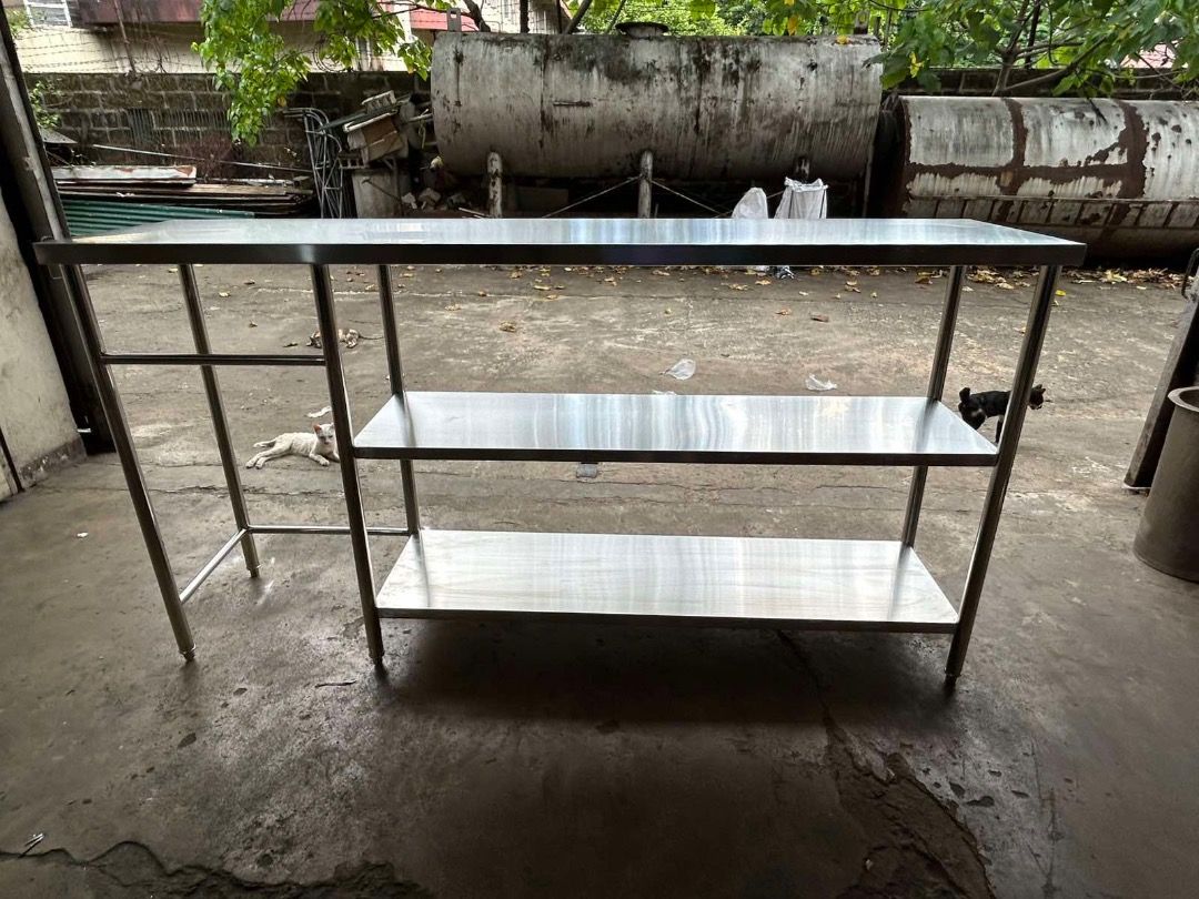 Stainless steel kitchen work table with double shelves (Category: Tables & Sets) located in Caloocan City. Submitted by brightdolphin_bfc4c6 (Listing ID 1471013534, Image 2). Description: Overall length: 2100 mm Overall height: 1100 mm Upper section height: 230 mm Left section width: 470 mm Main section width: 1476 mm - Heavy-duty commercial-grade stainless steel prep table - Clean and durable work surface on top - Two lower shelves provide extra