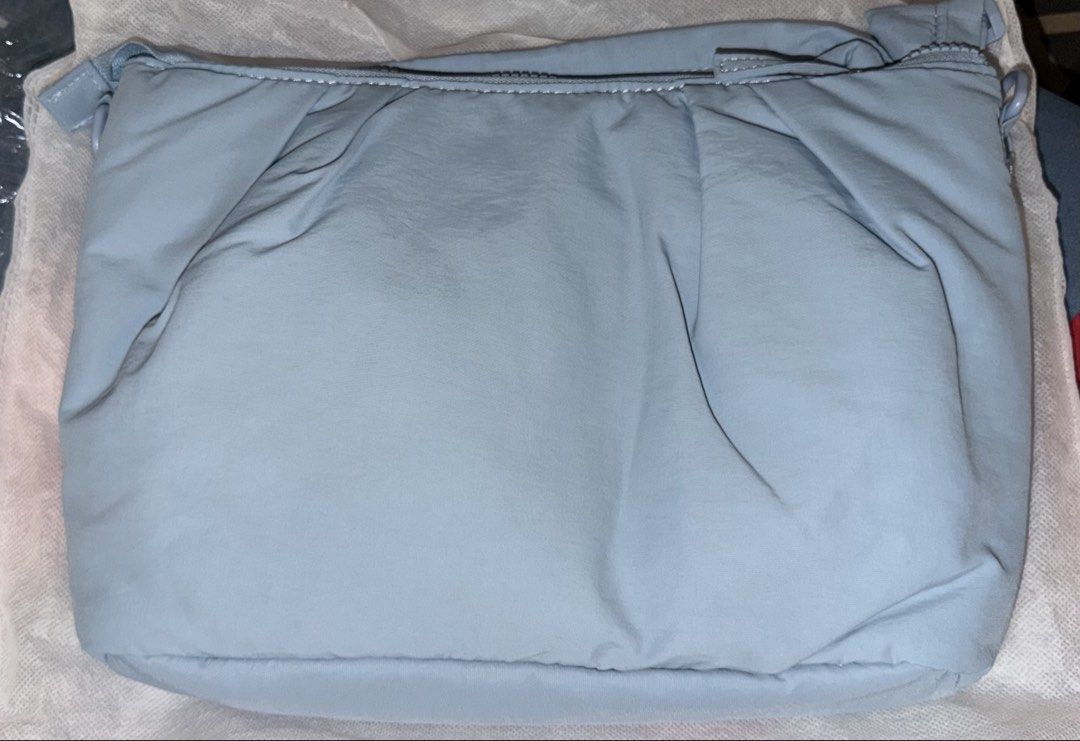 Straightforward Chirin Sling Bag in Dusty Blue (Category: Cross-body Bags) located in Manila. Submitted by nayeoniescart (Listing ID 1471094147, Image 2). Description: - Brand: Straightforward Chirin (BOUGHT AT SM SAN LAZARO) - Color: Dusty Blue - Material: Soft pleated nylon fabric - Closure: Zip top closure - Design: Structured base, adjustable strap clips on both sides, and centered square branded logo patch - Inclusions: Original dust bag and