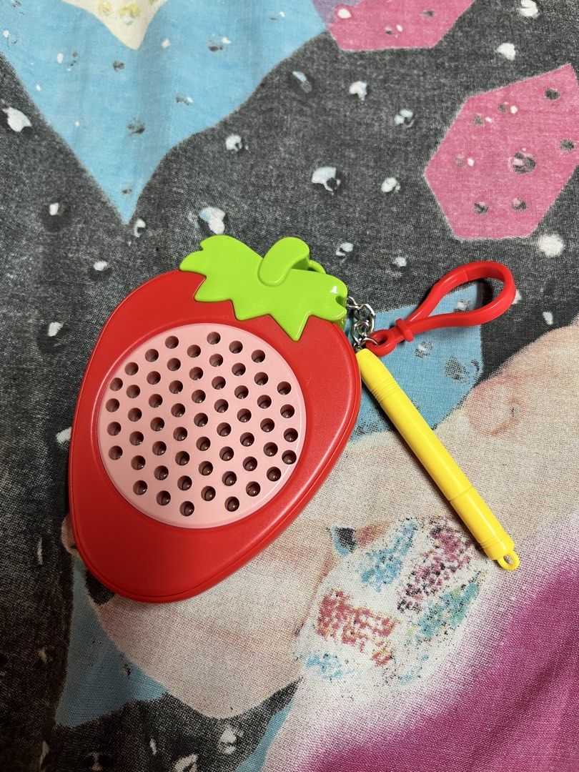 Strawberry shaped fidget learning toy with stylus (Category: Educational & Learning Toys) located in Manila. Submitted by leiluvsu (Listing ID 1471086595, Image 1). Description: - Adorable strawberry design: Bright red body with a green stem top - Interactive learning: Includes a pink perforated speaker grill and an attached yellow stylus - Portable: Comes with a red plastic loop and keychain clasp for easy hanging or carrying - Perfect gift: Fun