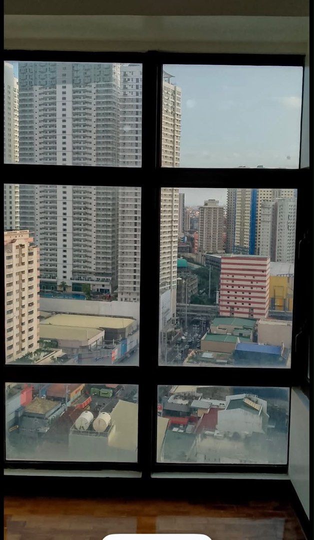 Studio apartment with city view and kitchen counter (Category: Apartments & Condos) located in Manila. Submitted by rainyrain (Listing ID 1471074536, Image 2). Description: - Move-in ready unfunished studio unit - Bright natural light with city views through big windows - Classic wooden parquet flooring - Kitchen with dark cabinets, granite countertop, sink, exhaust hood, and wall storage - Window-type air conditioner already installed.