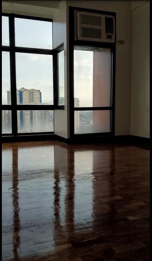 Studio apartment with city view and kitchen counter (Category: Apartments & Condos) located in Manila. Submitted by rainyrain (Listing ID 1471074536, Image 1). Description: - Move-in ready unfunished studio unit - Bright natural light with city views through big windows - Classic wooden parquet flooring - Kitchen with dark cabinets, granite countertop, sink, exhaust hood, and wall storage - Window-type air conditioner already installed.