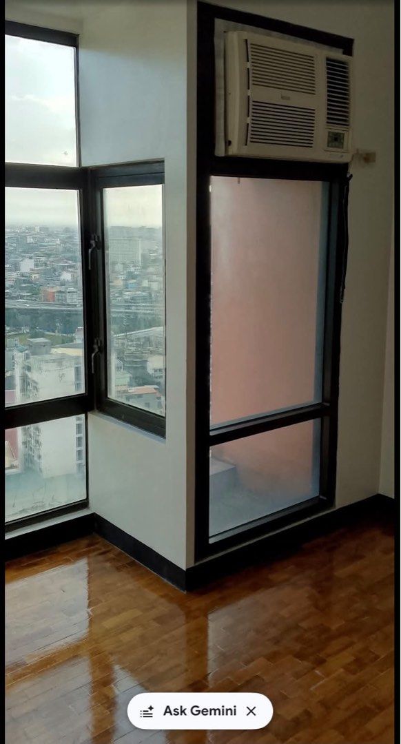 Studio apartment with city view and kitchen counter (Category: Apartments & Condos) located in Manila. Submitted by rainyrain (Listing ID 1471074536, Image 3). Description: - Move-in ready unfunished studio unit - Bright natural light with city views through big windows - Classic wooden parquet flooring - Kitchen with dark cabinets, granite countertop, sink, exhaust hood, and wall storage - Window-type air conditioner already installed.