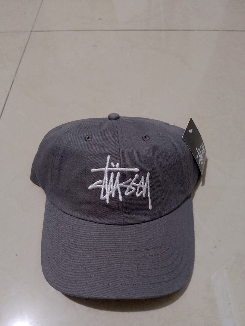 Stussy Stock Logo Strapback Cap Grey (Category: Caps & Hats) located in Manila. Submitted by thriftyboyzzz (Listing ID 1470998286, Image 1). Description: - Brand: Stussy - Style: Stock logo cap - Color: Charcoal grey with white embroidery - Material: 100% cotton, made in Bangladesh - Closure: Adjustable metal buckle with Stussy woven tag - Condition: Brand new with tags (BNWT).