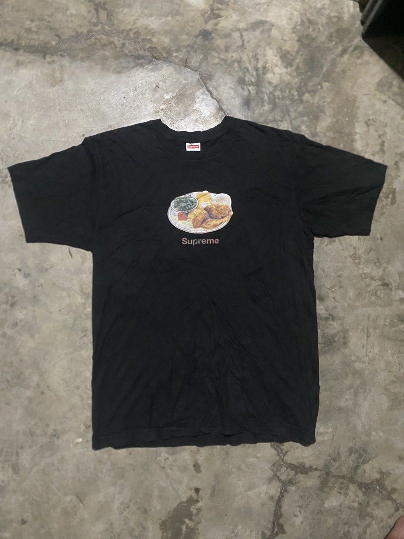 Supreme Fried Chicken Graphic Tee Black (Category: Tshirts & Polo Shirts ) located in Lucena. Submitted by puffinthrift (Listing ID 1470988705, Image 1). Description: - Brand: Supreme - Color: Black - Size: Large - Design: Fried chicken dinner graphic on chest - Details: Classic red box logo tag, clean white wash tag with blue text/RN number - Material: 100% pre-shrunk cotton (Made in USA) - Fit: Standard fit with short sleeves.