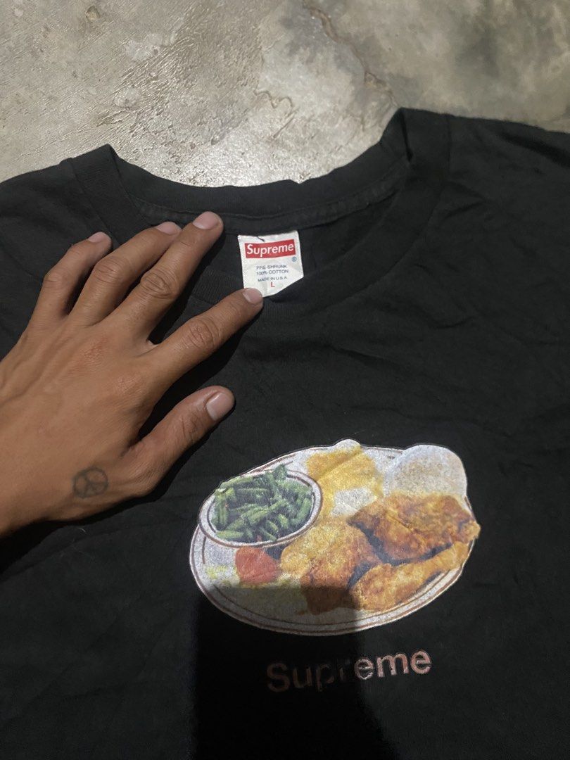 Supreme Fried Chicken Graphic Tee Black (Category: Tshirts & Polo Shirts ) located in Lucena. Submitted by puffinthrift (Listing ID 1470988705, Image 2). Description: - Brand: Supreme - Color: Black - Size: Large - Design: Fried chicken dinner graphic on chest - Details: Classic red box logo tag, clean white wash tag with blue text/RN number - Material: 100% pre-shrunk cotton (Made in USA) - Fit: Standard fit with short sleeves.
