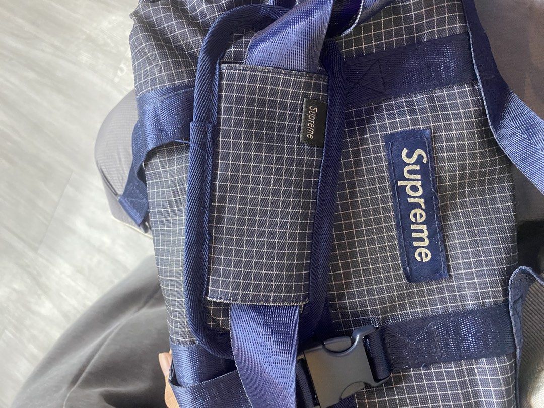 Supreme Grid Pattern Messenger Bag Blue (Category: Sling Bags) located in Manila. Submitted by lancee1208 (Listing ID 1471039069, Image 3). Description: Supreme messenger bag in dark blue grid pattern fabric. Dual buckle closure on the front flap with brand logo patch. Top handle and adjustable shoulder strap with padded grip. Spacious main compartment inside, zippered pocket, and inner dividers. Clean black lining throughout. Sturdy hardware and