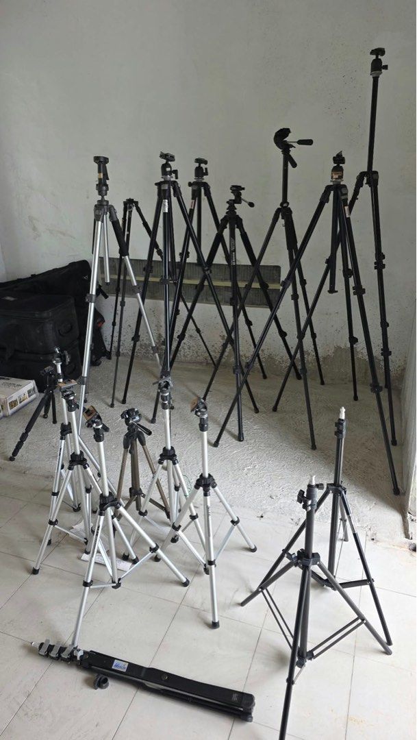 TAKE ALL Assorted Camera Tripods and Lighting Stands (Category: Tripods & Monopods) located in Pulilan. Submitted by sebbii (Listing ID 1470964715, Image 1). Description: - Studio clear-out sale: Camera tripods, light stands, and monopods available - Durable silver and black metal construction with sturdy builds - Selection includes lightweight aluminum models and heavy-duty tall stands - Some units come with standard pan heads - Folded carrying 