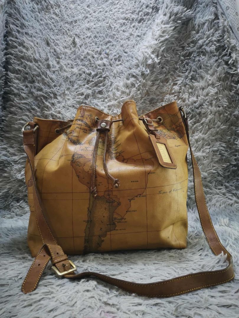 Tan Brown Vintage World Map Print Drawstring Bucket Bag (Category: Cross-body Bags) located in Santa Cruz. Submitted by jmy_surplus.2 (Listing ID 1471016164, Image 1). Description: Color: Tan Brown / Camel Brown Type/Kind: Bucket Bag / Crossbody Bag / Shoulder Bag Material: Body: Coated Canvas / Synthetic Leather (estimated) Strap & Trim: Leather-Look Material Lining: Fabric Hardware: Antique Gold-Tone Metal Style: Vintage Classic Retro Casual Tr