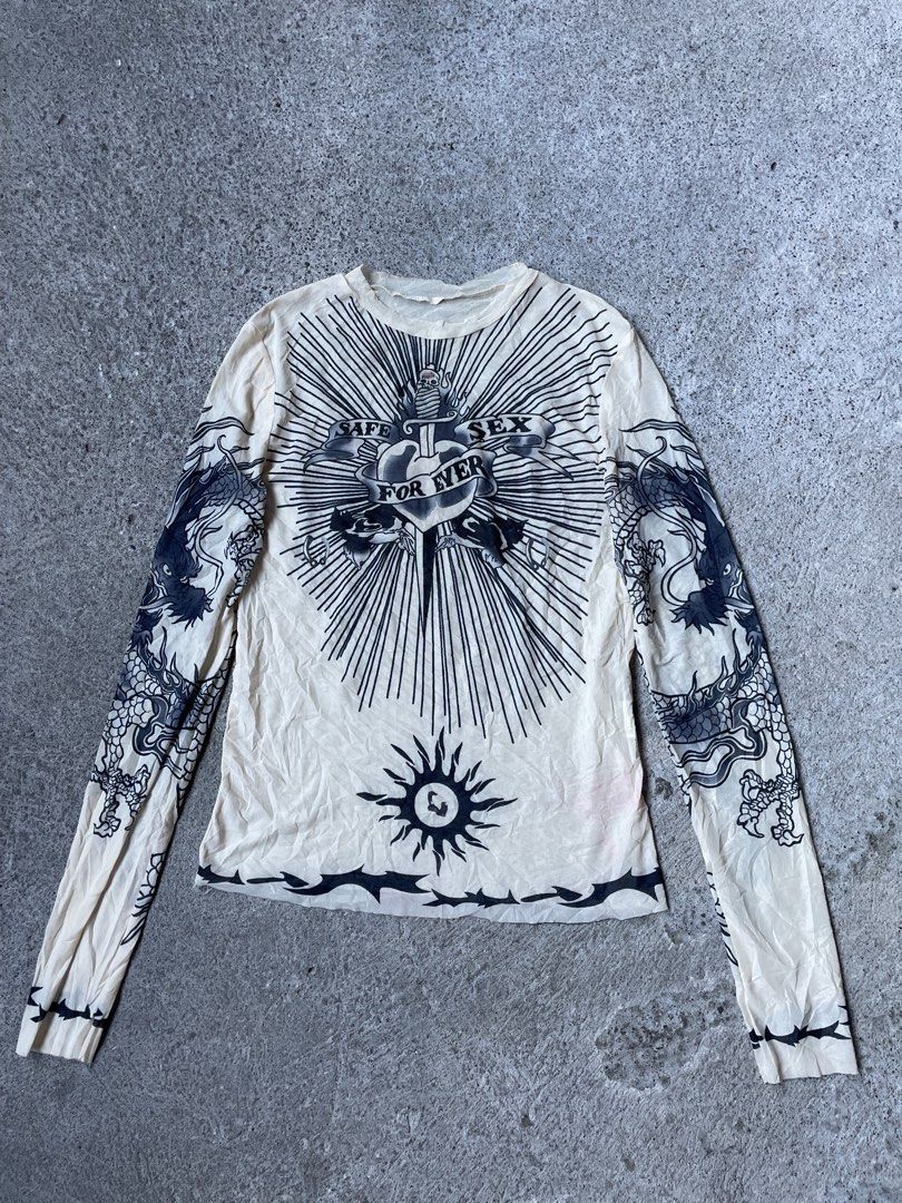 Tattoo Print Long Sleeve Mesh Top Size M (Category: Longsleeves) located in Siniloan. Submitted by rethr1ft (Listing ID 1471016793, Image 1). Description: - 22x15 dimes - Style: Beige long sleeve mesh top with tattoo graphic prints - Details: 'Safe Sex For Ever' chest text, dagger heart motif, sun graphic near hem, and dragon sleeve prints - Size: M (Tag attached) - Material: 95% polyester, 5% elastane.