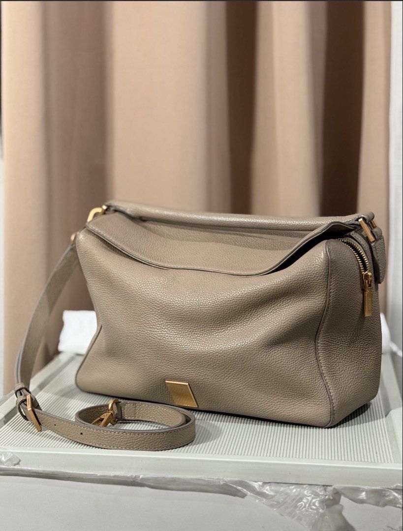 Taupe Leather Shoulder Bag With Gold Hardware (Category: Luxury Bags & Wallets) located in Pasay City. Submitted by maviemavz (Listing ID 1471009256, Image 1). Description: - Color & Material: Taupe textured pebble grain leather - Hardware: Sleek gold-tone accents - Strap: Detachable matching leather strap included - Closure & Pockets: Secure top zip closure with an exterior side zip pocket - Interior: Very spacious compartments with a clean, str