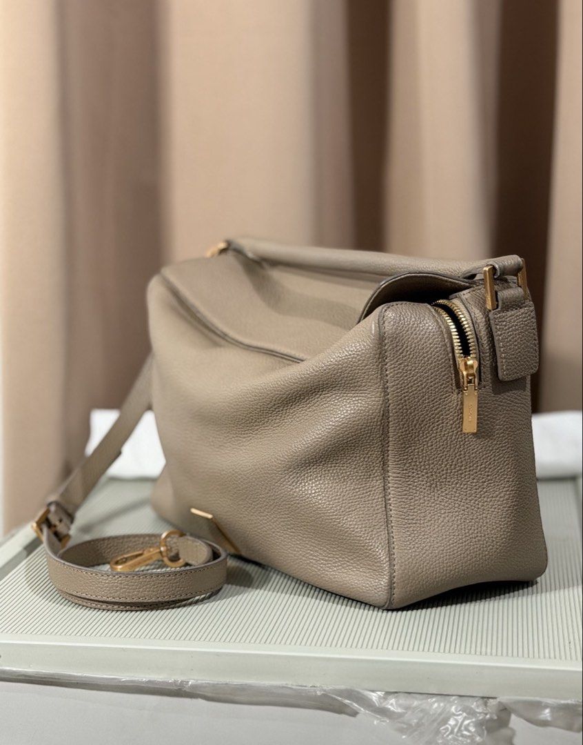 Taupe Leather Shoulder Bag With Gold Hardware (Category: Luxury Bags & Wallets) located in Pasay City. Submitted by maviemavz (Listing ID 1471009256, Image 2). Description: - Color & Material: Taupe textured pebble grain leather - Hardware: Sleek gold-tone accents - Strap: Detachable matching leather strap included - Closure & Pockets: Secure top zip closure with an exterior side zip pocket - Interior: Very spacious compartments with a clean, str