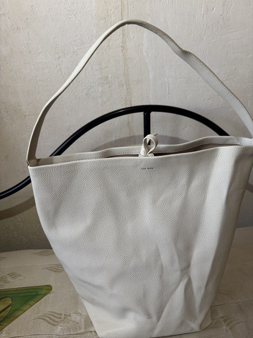 The Row Off-White Leather Shoulder Bag (Category: Shoulder Bags) located in Danao, Cebu. Submitted by jojie.1983 (Listing ID 1470980941, Image 2). Description: -Thrift Source and it has dirt inside pl see details photo - Brand: The Row made in Italy -Size: Large - Material: Premium off-white pebbled leather - Design: bucket shoulder bag - Handle: Single top handle for easy shoulder wear - Closure: Secure interior tie closure at the top - Details: