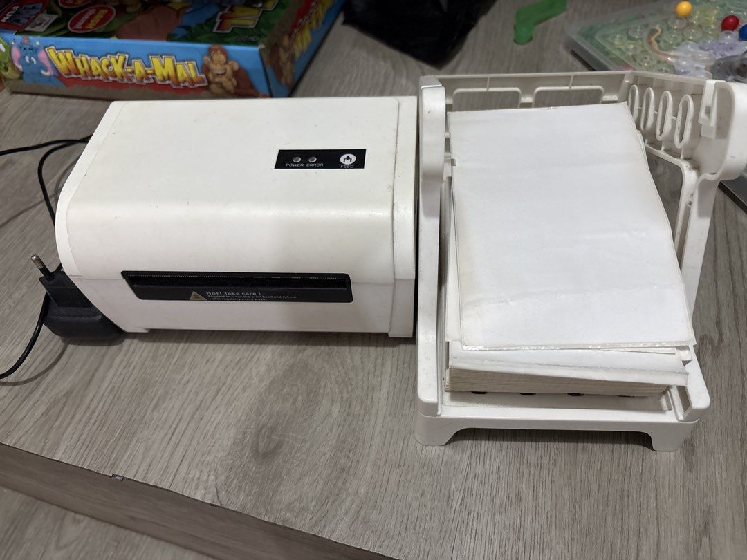 Thermal Label Printer with Stacked Paper Tray (Category: Printers, Scanners & Copiers) located in Manila. Submitted by ruizaaa (Listing ID 1470960017, Image 1). Description: - White thermal label printer, clean and ready for setup - Perfect for printing shipping labels and stickers - Includes power cable and power adapter - Comes with an external holder and a stack of blank fanfold labels - Rear ports: Power switch, power port, USB port, and netw