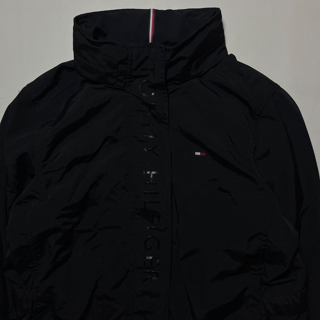 Tommy Hilfiger Black Windbreaker Jacket Size M (Category: Coats, Jackets and Outerwear) located in Caloocan City. Submitted by achilles_grails (Listing ID 1471056915, Image 2). Description: - Brand: Tommy Hilfiger - Style: Windbreaker jacket with full zip and snap button placket - Size: M - Color: Black with iconic red, white, and blue collar details - Design: Bold vertical logo lettering and embroidered chest flag - Material: Lightweight 100% ny