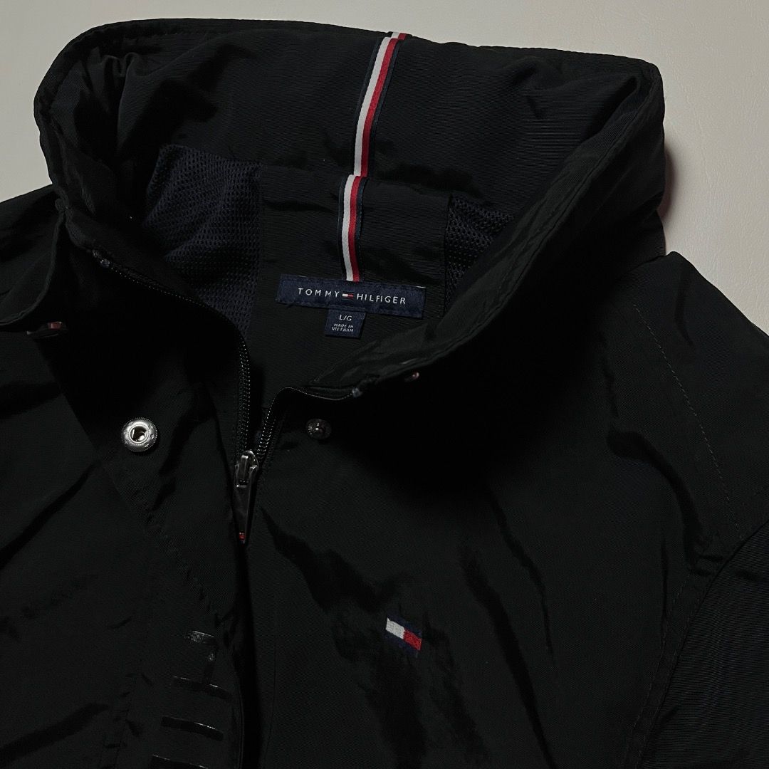 Tommy Hilfiger Black Windbreaker Jacket Size M (Category: Coats, Jackets and Outerwear) located in Caloocan City. Submitted by achilles_grails (Listing ID 1471056915, Image 3). Description: - Brand: Tommy Hilfiger - Style: Windbreaker jacket with full zip and snap button placket - Size: M - Color: Black with iconic red, white, and blue collar details - Design: Bold vertical logo lettering and embroidered chest flag - Material: Lightweight 100% ny