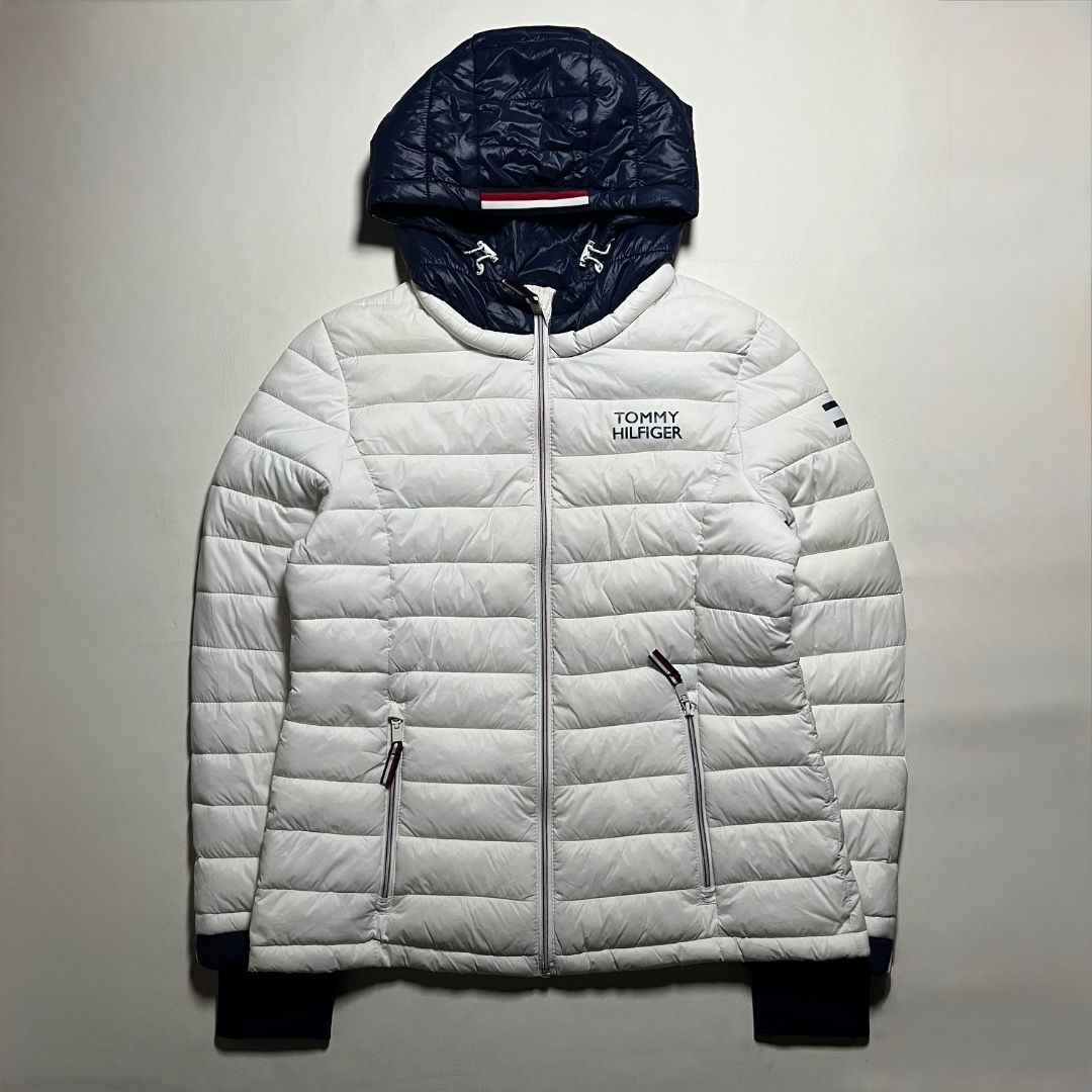 Tommy Hilfiger White Puffer Jacket With Navy Hood (Category: Coats, Jackets and Outerwear) located in Caloocan City. Submitted by achilles_grails (Listing ID 1471055039, Image 1). Description: - Authentic Tommy Hilfiger puffer jacket in crisp white with a contrasting dark blue hood - Full zip-up front closure with practical zipped side pockets - Iconic logo branding on the chest and left sleeve - Material: 100% nylon shell with 100% polyester fil