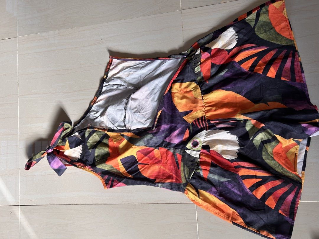 Tropical Leaf Print One-Shoulder Tie Strap Romper (Category: Rompers) located in Caloocan City. Submitted by declutterieee (Listing ID 1471007199, Image 3). Description: - Colors: Vibrant orange, purple, red, and green on a dark background - Details: Cute tie strap accent, easy pullover style (no zippers or buttons) - Fabric: Lightweight and breathable, ideal for warm weather and beach getaways - Condition: Excellent, vibrant colors with zero sig