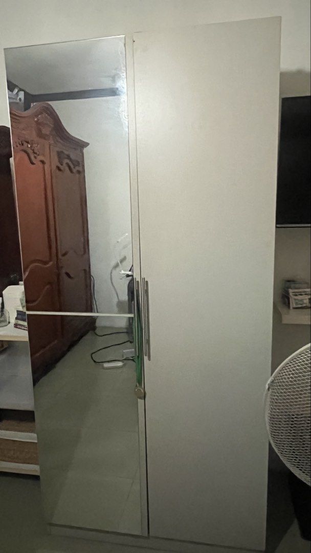 Two door wardrobe with full length mirror (Category: Shelves, Cabinets & Racks) located in Talavera. Submitted by dnms_ (Listing ID 1471028251, Image 1). Description: - Color & Material: Light grey wood with sturdy construction - Door Left: Features an attached full-length mirror - Door Right: Fitted with sleek, long vertical silver handles - Interior Storage: Spacious hanging area, multiple shelves, and a convenient middle pullout drawer - Condi