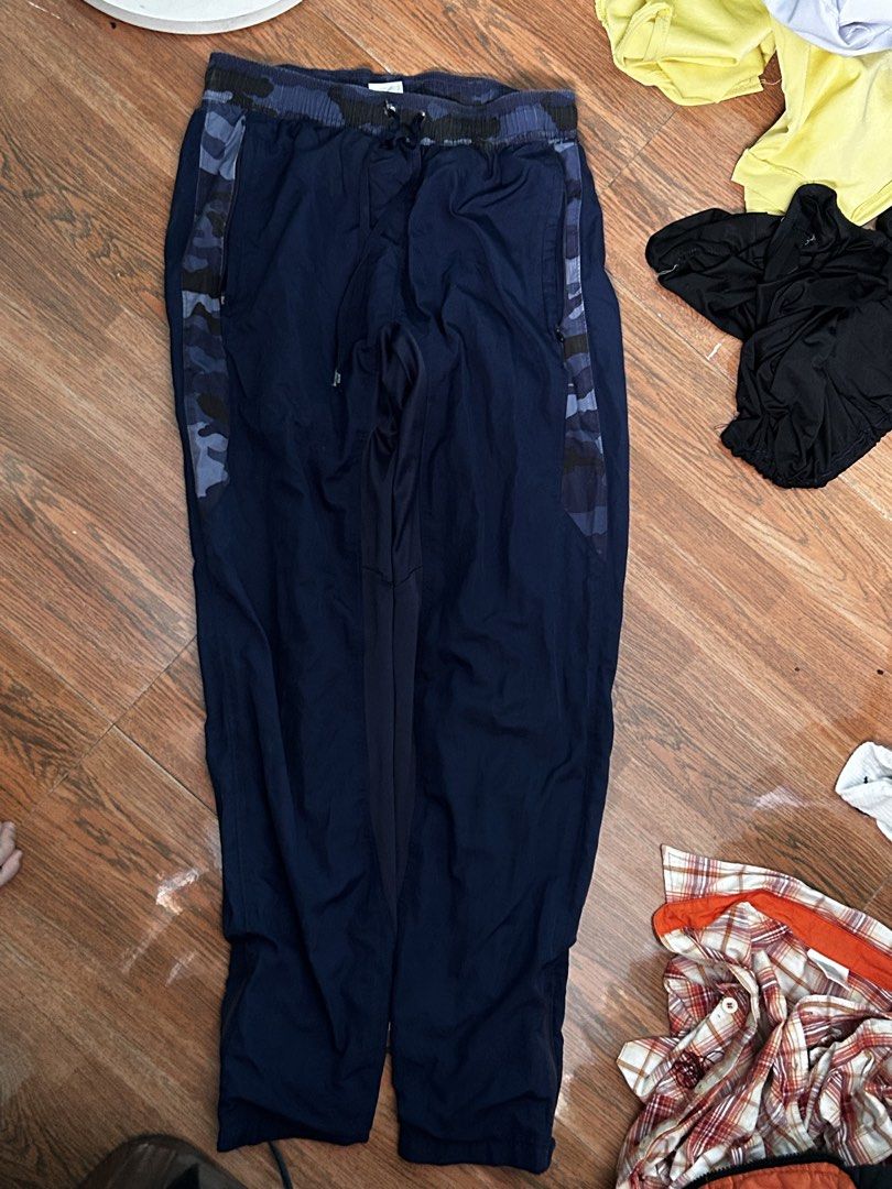 Under Armour Blue Camo Track Pants (Category: Joggers) located in Manila. Submitted by lovely.453 (Listing ID 1470960189, Image 2). Description: - Brand: Under Armour size 26-30 adjustable waist - Color: Navy blue with blue camo waistband and side panels - Material: 100% polyester (lightweight and breathable) - Waist: Elastic with drawstring closure - Pockets: Secure zippered pockets on both sides - Origin: Made in Vietnam - Condition: Excellent 