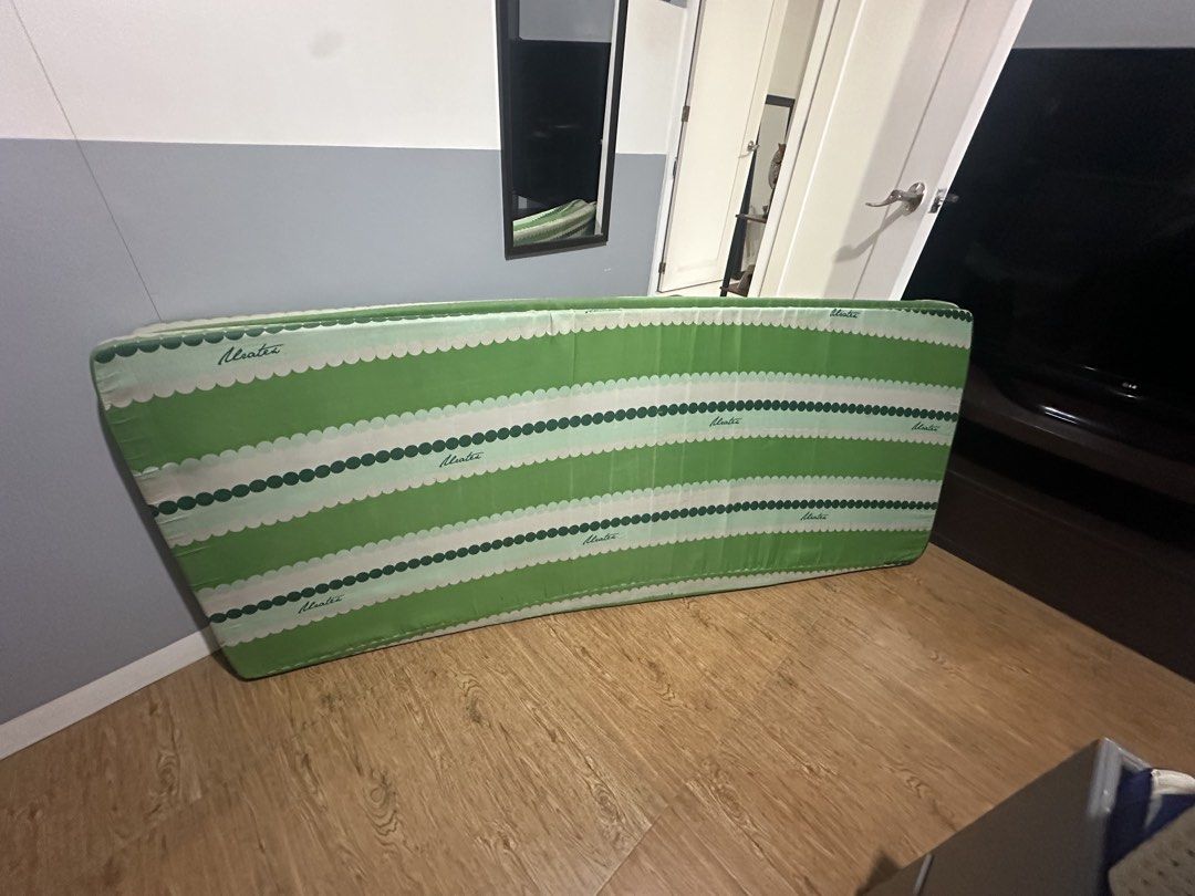 Uratex green and white striped foldable mattress (Category: Bed Frames & Mattresses) located in Quezon City. Submitted by _samanthajyc (Listing ID 1471066482, Image 2). Description: - Brand: Uratex - Design: Green and white stripes with a scalloped border - Condition: Clean fabric surface - Storage: Easy to fold and store away - Ideal for: Guest rooms, sleepovers, or extra lounging space - 2 pieces - Price is Negotiable.