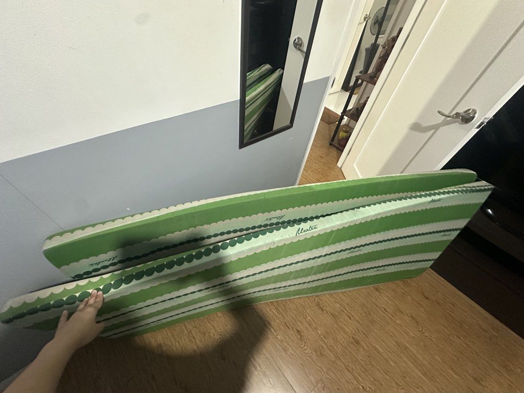 Uratex green and white striped foldable mattress (Category: Bed Frames & Mattresses) located in Quezon City. Submitted by _samanthajyc (Listing ID 1471066482, Image 1). Description: - Brand: Uratex - Design: Green and white stripes with a scalloped border - Condition: Clean fabric surface - Storage: Easy to fold and store away - Ideal for: Guest rooms, sleepovers, or extra lounging space - 2 pieces - Price is Negotiable.