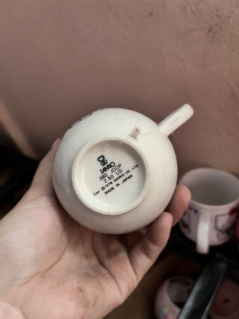 Vintage 1976 Sanrio Hello Kitty Ceramic Mug (Category: Coffee & Tea Tableware) located in Manila. Submitted by janetecson05 (Listing ID 1471118119, Image 2). Description: - Authentic vintage Sanrio Kitty mug (1976 stamp) - Made in Japan with a classic white ceramic body and rounded shape - Features a cute Kitty bear graphic - Comfortable handle for daily use - Condition: Dusty from storage, just needs a quick wash before use - Perfect for Sanrio 