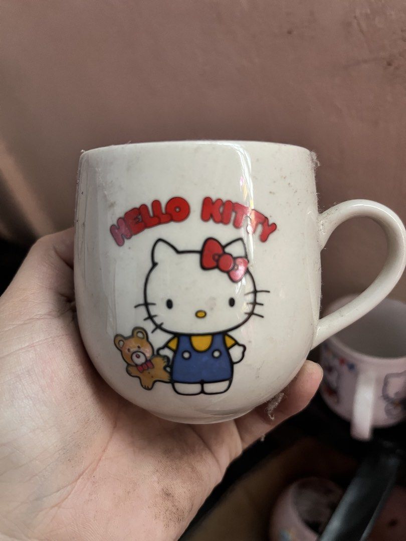 Vintage 1976 Sanrio Hello Kitty Ceramic Mug (Category: Coffee & Tea Tableware) located in Manila. Submitted by janetecson05 (Listing ID 1471118119, Image 1). Description: - Authentic vintage Sanrio Kitty mug (1976 stamp) - Made in Japan with a classic white ceramic body and rounded shape - Features a cute Kitty bear graphic - Comfortable handle for daily use - Condition: Dusty from storage, just needs a quick wash before use - Perfect for Sanrio 