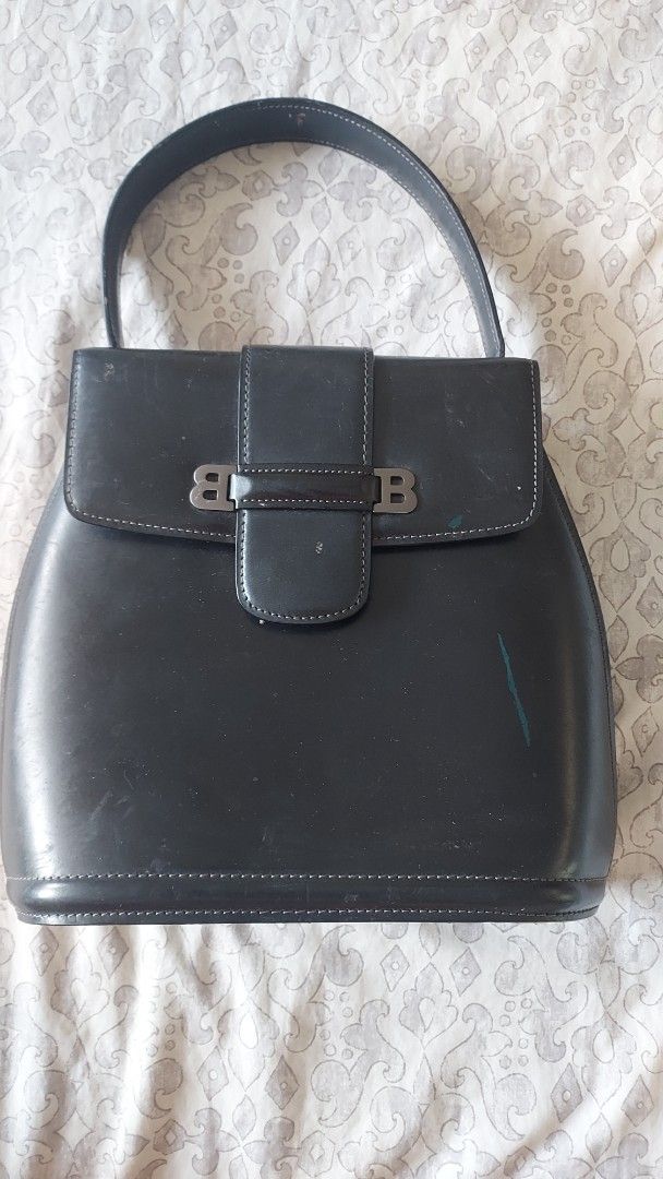 Vintage Bally Black Leather Bag (Category: Luxury Bags & Wallets) located in Cavite. Submitted by bonita2230 (Listing ID 1470957610, Image 1). Description: - Brand: Authentic Vintage Bally - Material: Black genuine leather with monogram fabric lining - Design: Structured shape, front flap closure with signature 'B' metal clasp - Features: internal zippered pocket, and 'genuine leather' stamp - Condition: Pre-loved with visible scuffs and surface 