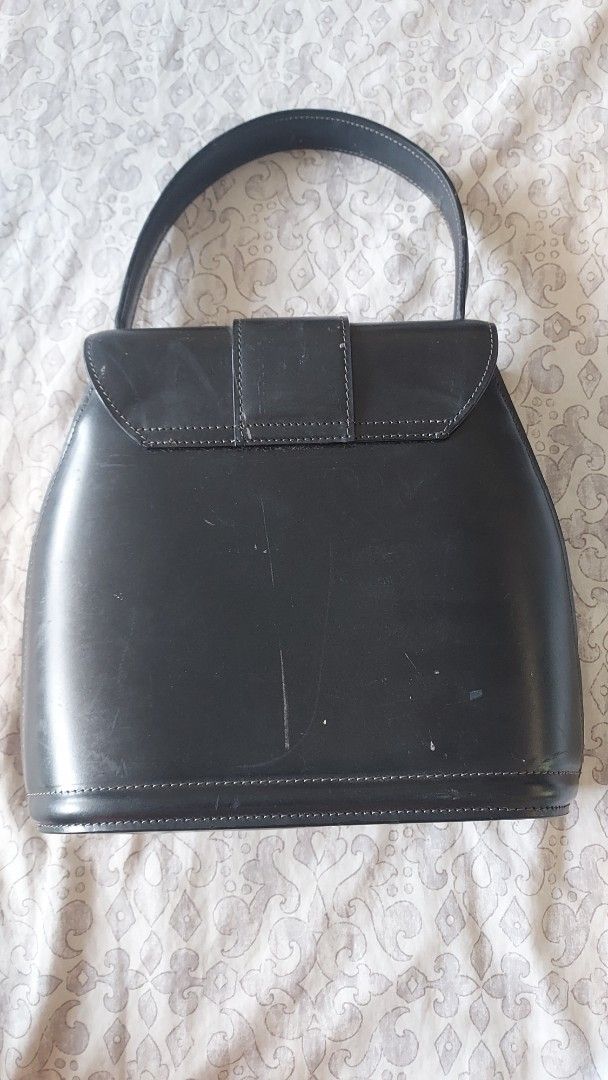 Vintage Bally Black Leather Bag (Category: Luxury Bags & Wallets) located in Cavite. Submitted by bonita2230 (Listing ID 1470957610, Image 2). Description: - Brand: Authentic Vintage Bally - Material: Black genuine leather with monogram fabric lining - Design: Structured shape, front flap closure with signature 'B' metal clasp - Features: internal zippered pocket, and 'genuine leather' stamp - Condition: Pre-loved with visible scuffs and surface 