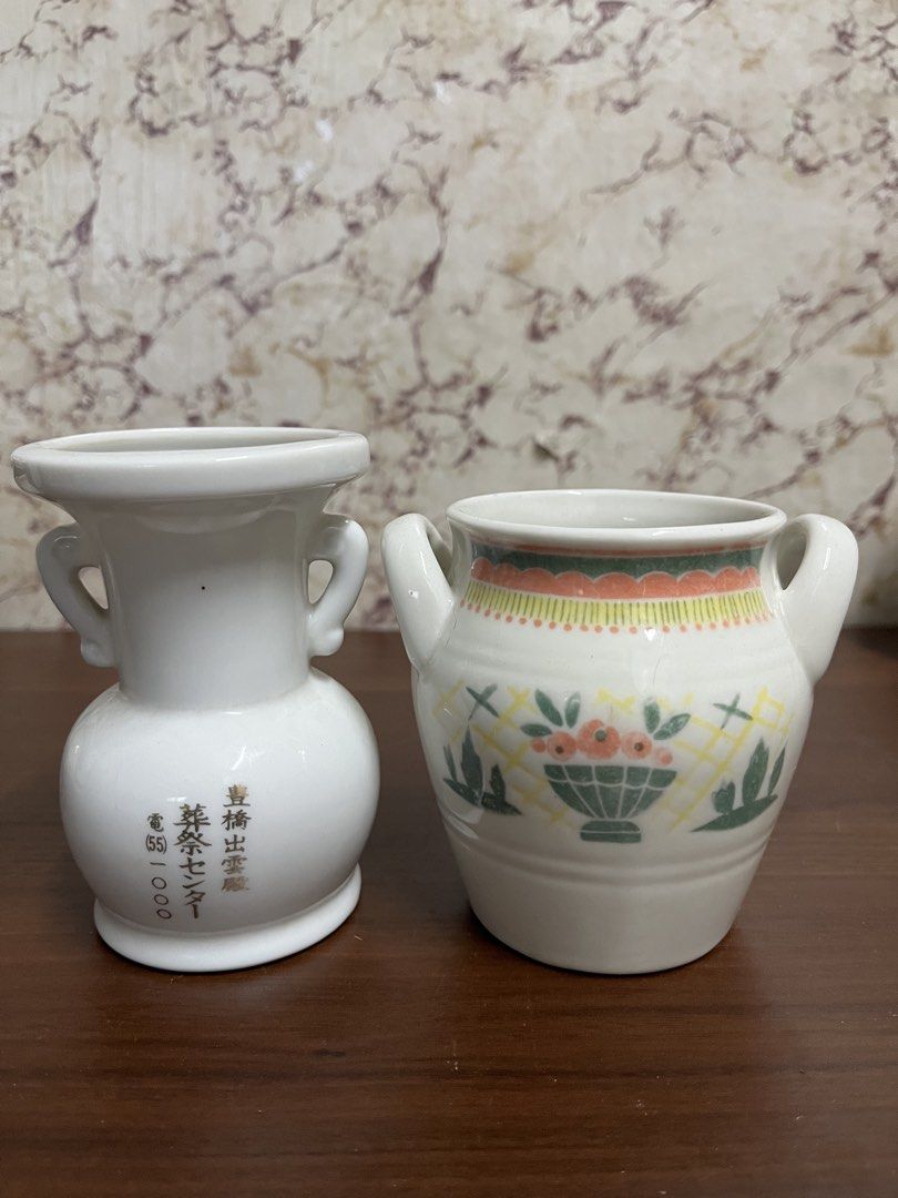 Vintage Ceramic Vases Pair with Handles and Floral Pattern (Category: Vases & Decorative Bowls) located in Manila. Submitted by kayerrr.gem (Listing ID 1471046468, Image 1). Description: - Set of 2 vintage white glazed ceramic vases with double side handles - Vase 1: Features elegant gold Japanese lettering and telephone number print - Vase 2: Decorated with a vibrant basket and flower pattern near the base, plus yellow and orange top rim trim - 