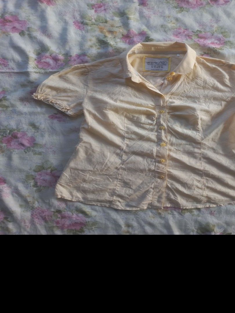 Vintage Esprit Yellow Short Sleeve Button-Down Blouse (Category: Blouses) located in Davao. Submitted by bloodyriz (Listing ID 1470933337, Image 2). Description: - Brand: Vintage Esprit - Color: Soft yellow with subtle vertical pinstripes - Details: Classic pointed collar, front ruching along the placket - Sleeves: Short puff sleeves with playful ruffled cuffs - Material: Lightweight and comfortable - Condition: Great basic for casual wear or sma