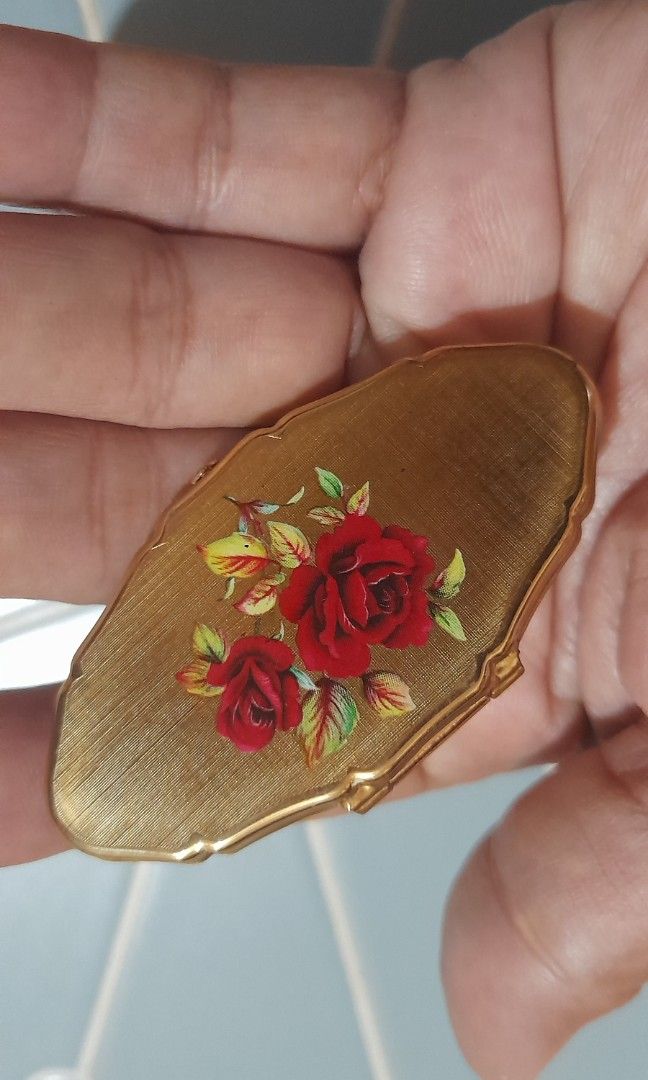 Vintage Gold Lipstick Case with Mirror (Category: Makeup) located in Bocaue. Submitted by marajapansurplus (Listing ID 1470971055, Image 1). Description: - Vintage gold lipstick holder with built-in side mirror - Features a vibrant red rose floral design on textured gold casing - Detailed with diamond cut-outs and intricate engraved markings - Compact and lightweight, fits easily in small purses or handbags - Stunning retro piece for your vanity 