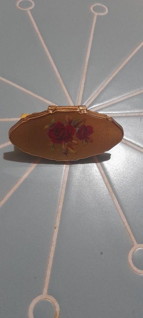 Vintage Gold Lipstick Case with Mirror (Category: Makeup) located in Bocaue. Submitted by marajapansurplus (Listing ID 1470971055, Image 3). Description: - Vintage gold lipstick holder with built-in side mirror - Features a vibrant red rose floral design on textured gold casing - Detailed with diamond cut-outs and intricate engraved markings - Compact and lightweight, fits easily in small purses or handbags - Stunning retro piece for your vanity 