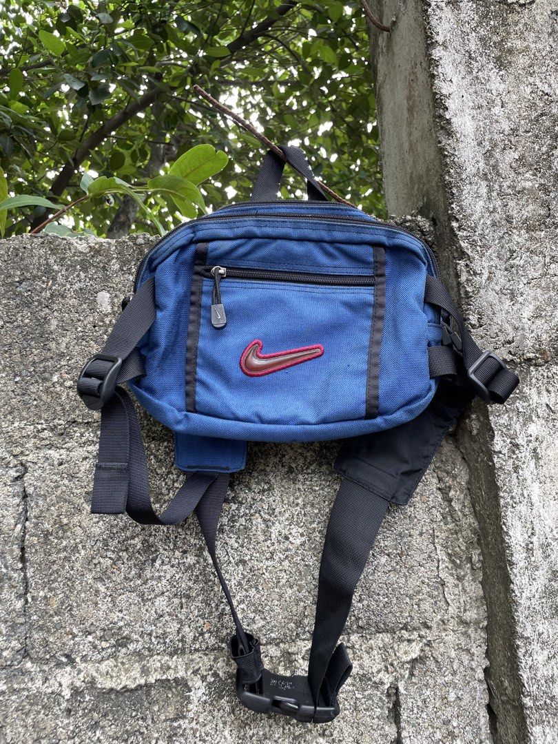 Vintage Nike Blue Crossbody Sling Bag (Category: Sling Bags) located in Cebu City. Submitted by lucky.finds.ph (Listing ID 1470972793, Image 1). Description: - Color: Royal blue body with black straps and hardware - Brand: Nike with branded Woojin Duraflex buckle - Design: Distinct raised red and brown Nike swoosh on the front zippered pocket - Storage: Multiple compartments including an additional zip compartment on the main strap for daily carr