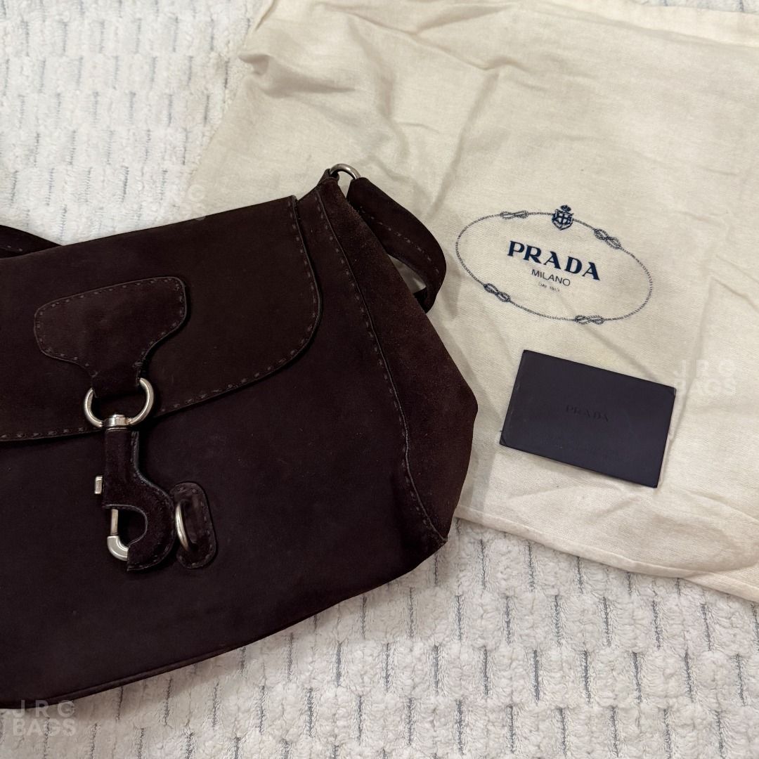 Vintage Prada Suede Shoulder Bag Brown (Category: Luxury Bags & Wallets) located in Paranaque City. Submitted by juliasmomsy (Listing ID 1470998116, Image 2). Description: Selling my pre-loved bags! :) - Authentic Vintage Prada Suede shoulder bag - SIZE: L:29 cm, H: 24 cm, W: 12 cm, Handle drop: 22 cm - COLOR: Classic dark brown - HARDWARE: Silver-tone hardware with secure clasp closure. With a triangle Prada logo on the side. - MATERIAL: Suede. 