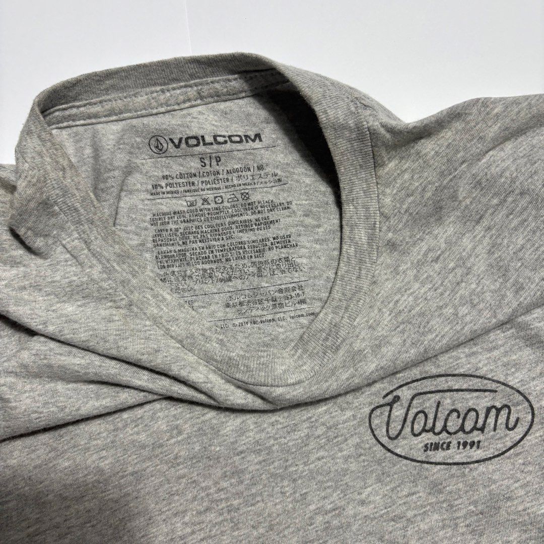 Volcom Heather Grey T-Shirt Size S (Category: Tshirts & Polo Shirts ) located in San Fernando. Submitted by lumang_gamit (Listing ID 1471065750, Image 3). Description: - Brand: Volcom - Size: S/P - Color: Grey - Material: 90% cotton, 10% polyester blend - Design: Small front chest logo and large blue cursive back logo - Neckline: Crew neck with short sleeves - Comfort: Tagless printed inner collar.