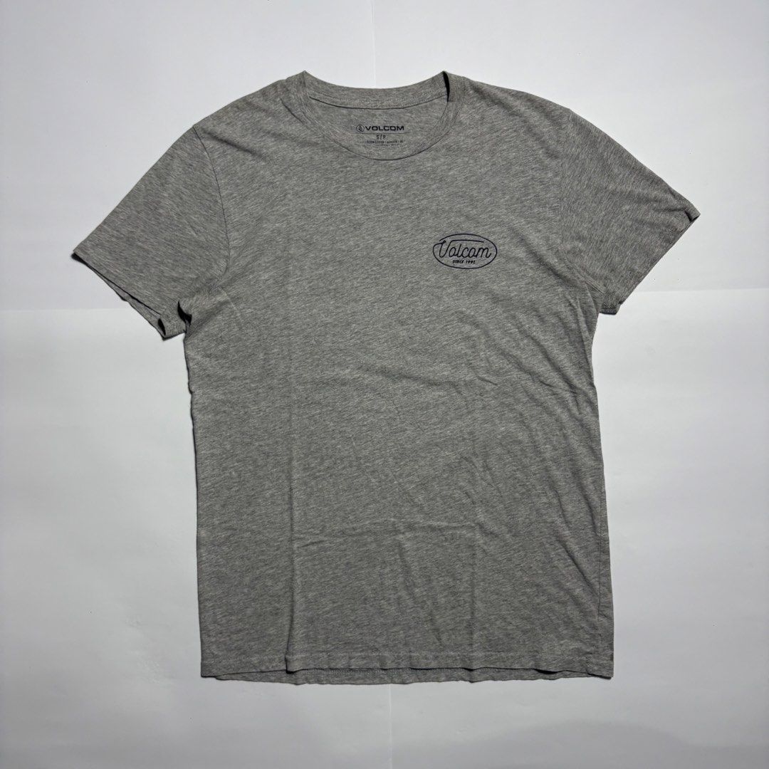 Volcom Heather Grey T-Shirt Size S (Category: Tshirts & Polo Shirts ) located in San Fernando. Submitted by lumang_gamit (Listing ID 1471065750, Image 1). Description: - Brand: Volcom - Size: S/P - Color: Grey - Material: 90% cotton, 10% polyester blend - Design: Small front chest logo and large blue cursive back logo - Neckline: Crew neck with short sleeves - Comfort: Tagless printed inner collar.