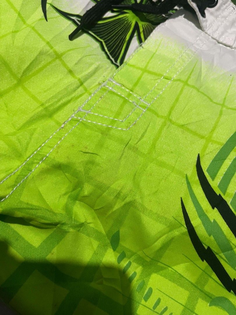 Volcom Mod Tech 34 Green Board Shorts Swim Trunks (Category: Swim Trunks & Board Shorts) located in Gumaca. Submitted by makuliti (Listing ID 1470976092, Image 3). Description: - Brand/Model: Volcom Mod Tech board shorts - Size: 34 - Colorway: Lime green, black, and white with bold tribal and checkerboard fade graphics - Features: Side cargo pocket with velcro flap and secure drawstring waist closure - Condition: Great vintage surf aesthetic, not