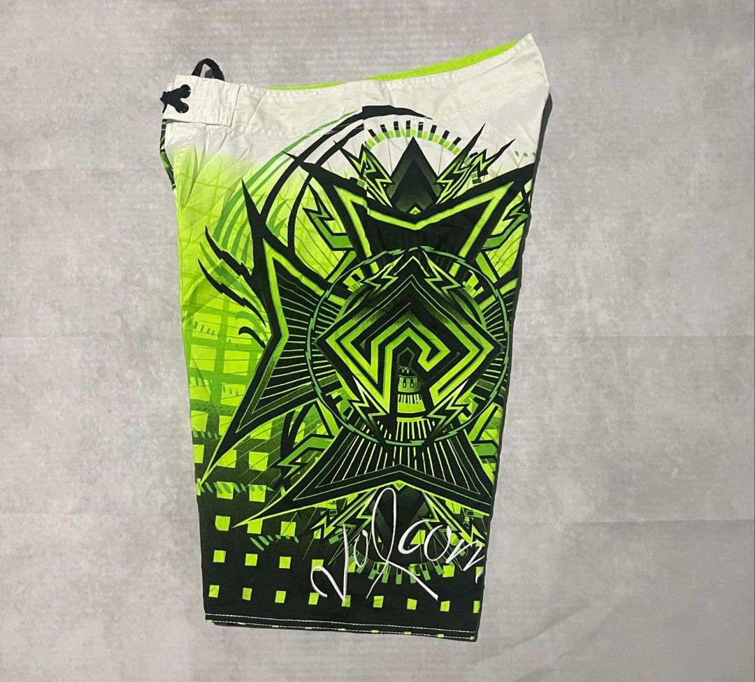 Volcom Mod Tech 34 Green Board Shorts Swim Trunks (Category: Swim Trunks & Board Shorts) located in Gumaca. Submitted by makuliti (Listing ID 1470976092, Image 2). Description: - Brand/Model: Volcom Mod Tech board shorts - Size: 34 - Colorway: Lime green, black, and white with bold tribal and checkerboard fade graphics - Features: Side cargo pocket with velcro flap and secure drawstring waist closure - Condition: Great vintage surf aesthetic, not