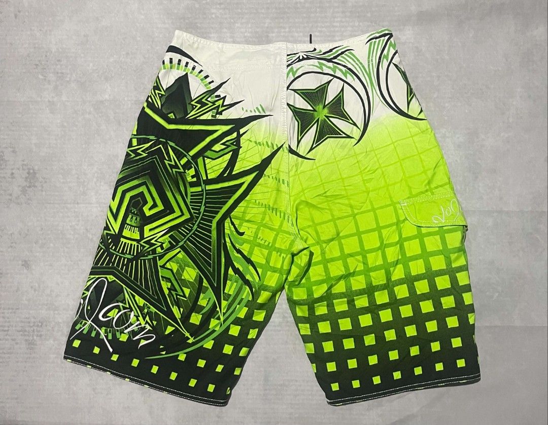 Volcom Mod Tech 34 Green Board Shorts Swim Trunks (Category: Swim Trunks & Board Shorts) located in Gumaca. Submitted by makuliti (Listing ID 1470976092, Image 1). Description: - Brand/Model: Volcom Mod Tech board shorts - Size: 34 - Colorway: Lime green, black, and white with bold tribal and checkerboard fade graphics - Features: Side cargo pocket with velcro flap and secure drawstring waist closure - Condition: Great vintage surf aesthetic, not