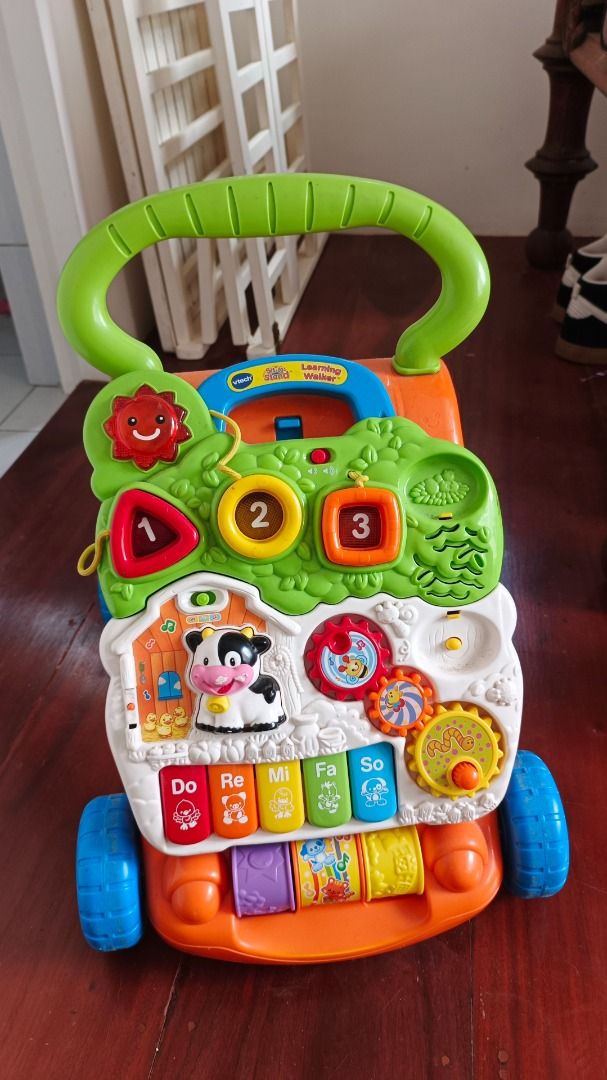 VTech Baby Learning Walker Activity Center (Category: Infant Playtime) located in Makati City. Submitted by ayekai (Listing ID 1471089654, Image 2). Description: - VTech interactive learning walker in bright green, orange, and white - Equipped with colorful shape sorters, spinning gears, and piano keys - Helps babies and toddlers with balance and first steps - Keeps little ones busy with fun, interactive features - Wheels roll smoothly and all bu
