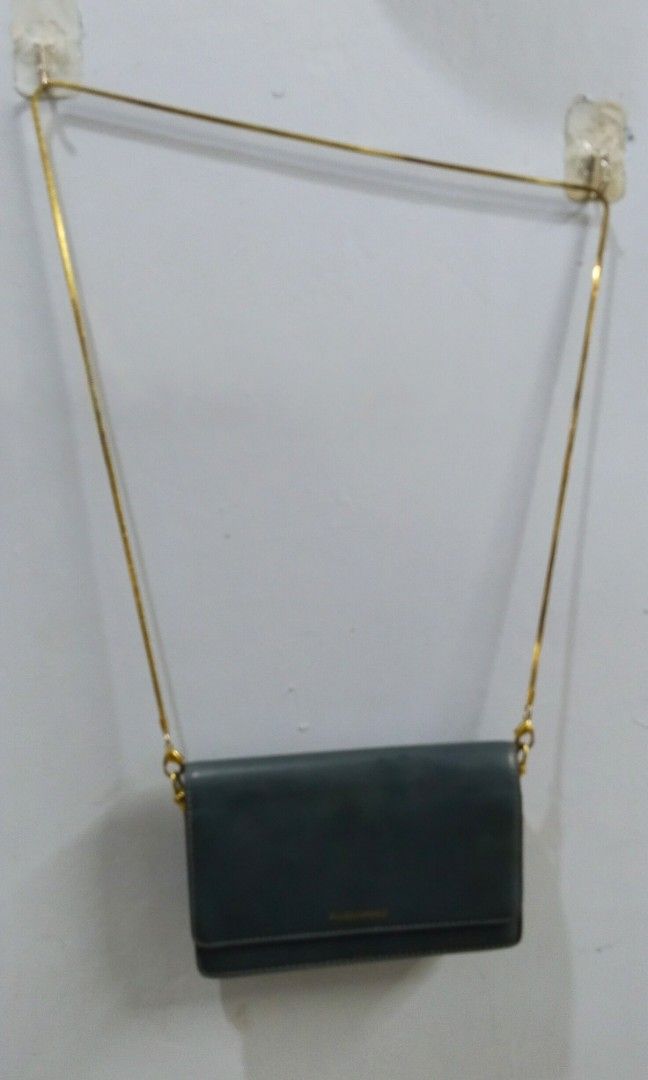 Wallet chain sling bag (Category: Cross-body Bags) located in Trece Martires City. Submitted by vherma (Listing ID 1470948544, Image 1). Description: Color: Dark green, teal, or deep ocean blue Strap: Detachable thin gold-tone metal chain Closure: Magnetic snap flap closure.