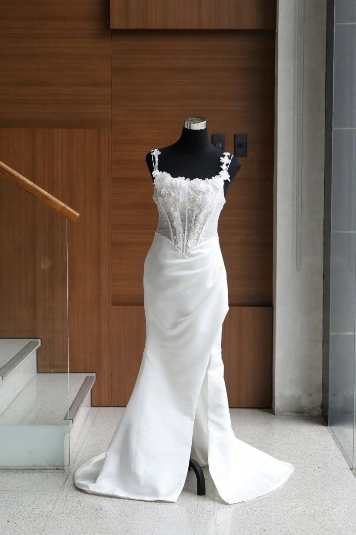 Wedding Gown (Category: Evening dresses & gowns) located in Manila. Submitted by ra.repecilo (Listing ID 1470997095, Image 1). Description: - Style: White mermaid silhouette wedding dress with a subtle train - Bodice: Structured corset with sheer panels, delicate floral appliqués, and beading along the square neckline and straps - Details: Fitted waist, satin skirt with a trendy front slit, and a hidden back zipper - Condition: Worn once for a fe