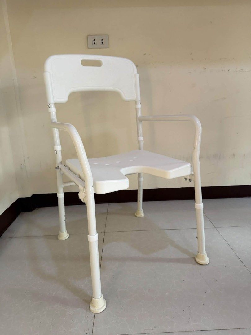 White Adjustable Shower Chair with Backrest and Armrests (Category: Chairs) located in Manila. Submitted by calmdolphin.87b0e4 (Listing ID 1470955642, Image 1). Description: - White shower chair with a sturdy metal frame and adjustable legs - U-shaped cutout seat for easy personal hygiene access - Equipped with comfortable armrests and a supportive backrest with a grab handle - Non-slip rubber tips on all four feet for safety and stability - Fold