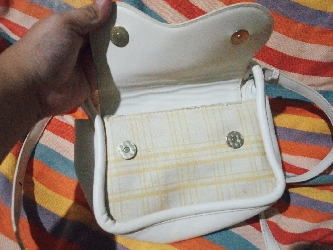 White crossbody bag with plaid front flap and strap (Category: Cross-body Bags) located in Manila. Submitted by littlelove25 (Listing ID 1471096528, Image 2). Description: - Color & Design: Elegant white crossbody bag with a stylish yellow plaid fabric accent - Closure: Secure magnetic snap under the front flap plus a main compartment zipper - Interior: Fully lined to protect your daily essentials - Strap: Comfortable and fully adjustable white s