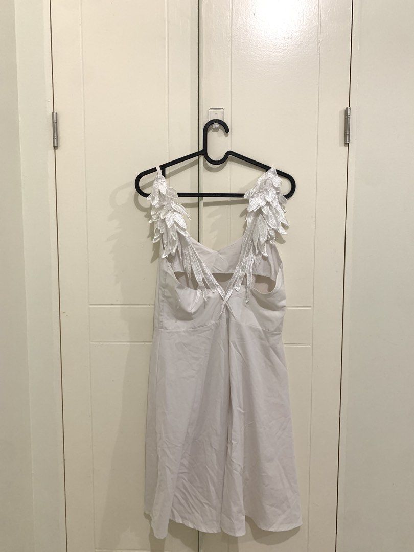 White Dress with Angel Wing Straps (Category: Dresses) located in Pasig City. Submitted by lovedbyri (Listing ID 1471016809, Image 3). Description: - Style: White sleeveless midi dress with a flared skirt - Unique Details: Embroidered leaf or wing accents hanging from the straps down the back, plus a stylish upper back cutout - Length: Midi - Color/Fabric: Clean neutral fabric, perfect for various occasions - Closure: Simple zip or slip construct